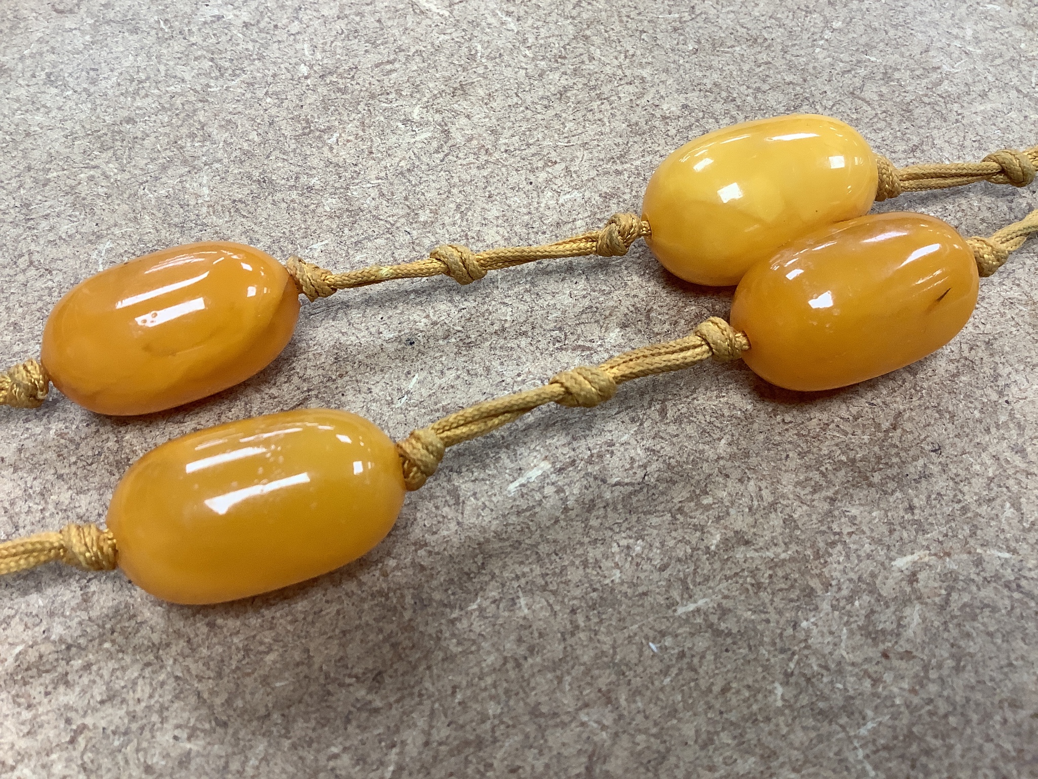 A single strand oval amber bead pendant necklace, 92cm, gross weight 60 grams.